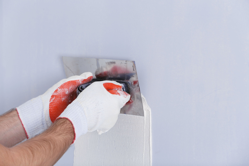 builder-using-plastering-tool-finishing-wall.jpg